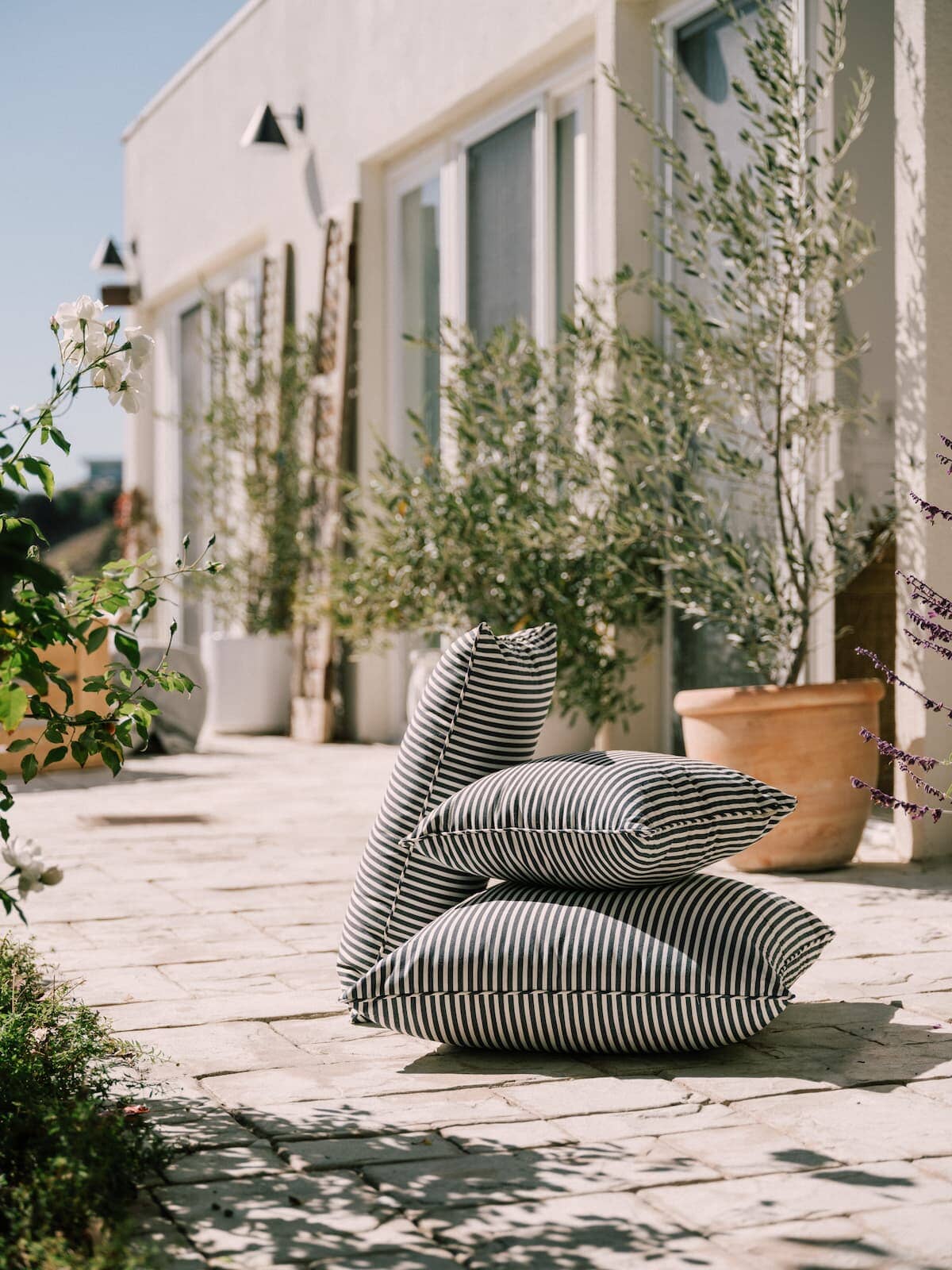 3 outdoor cushions stacked on a patio in the sun
