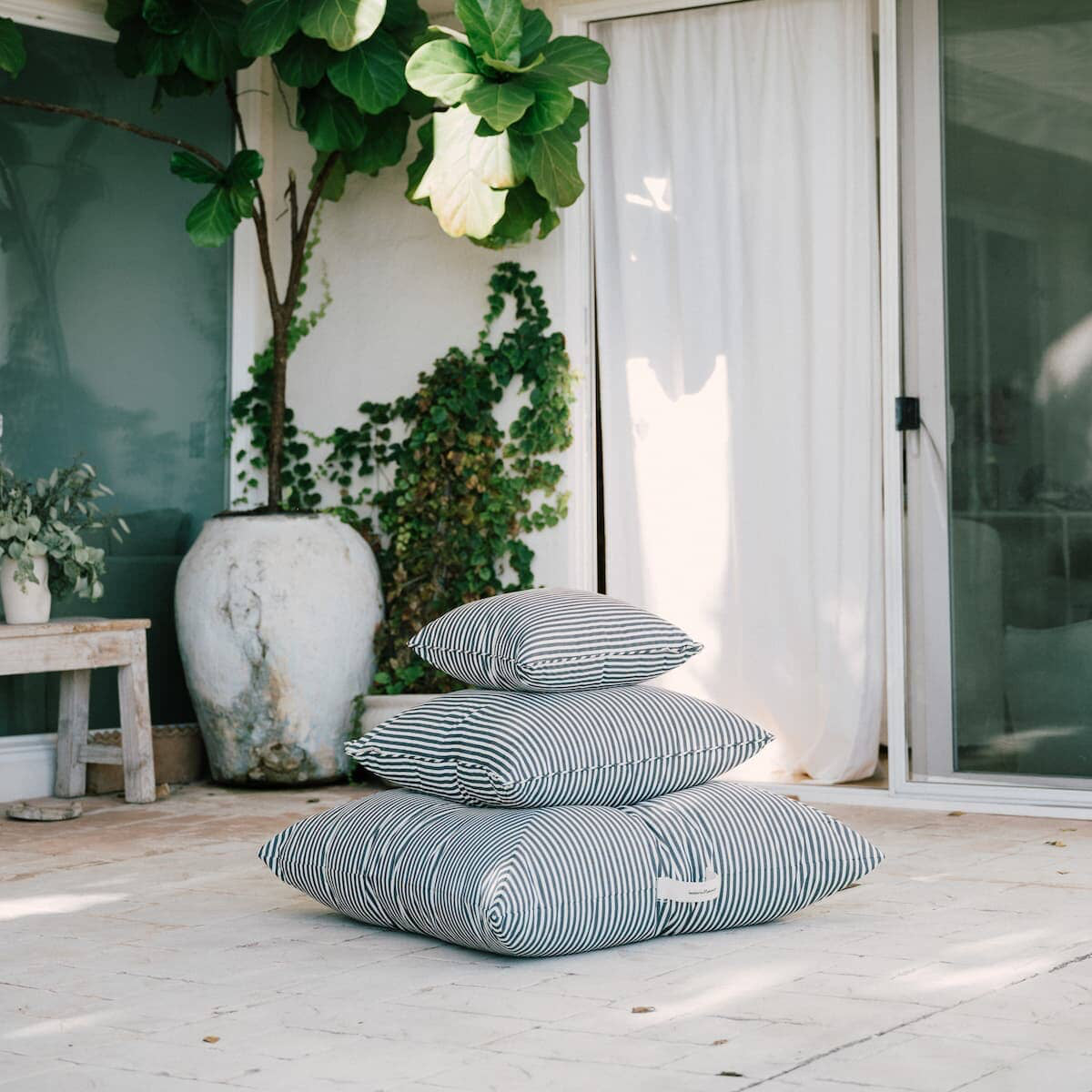 3 outdoor cushions stacked on a patio