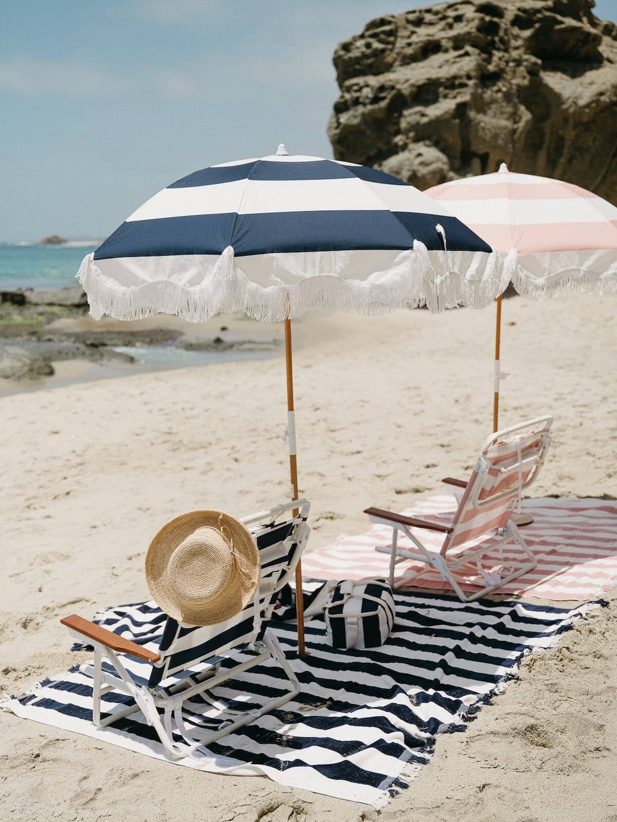 beach setting with navy blanket, umbrella and chair