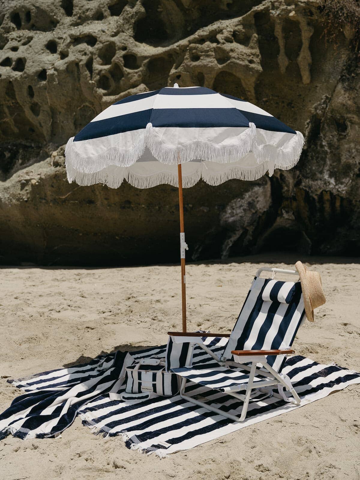 beach setting with navy blanket, umbrella and chair