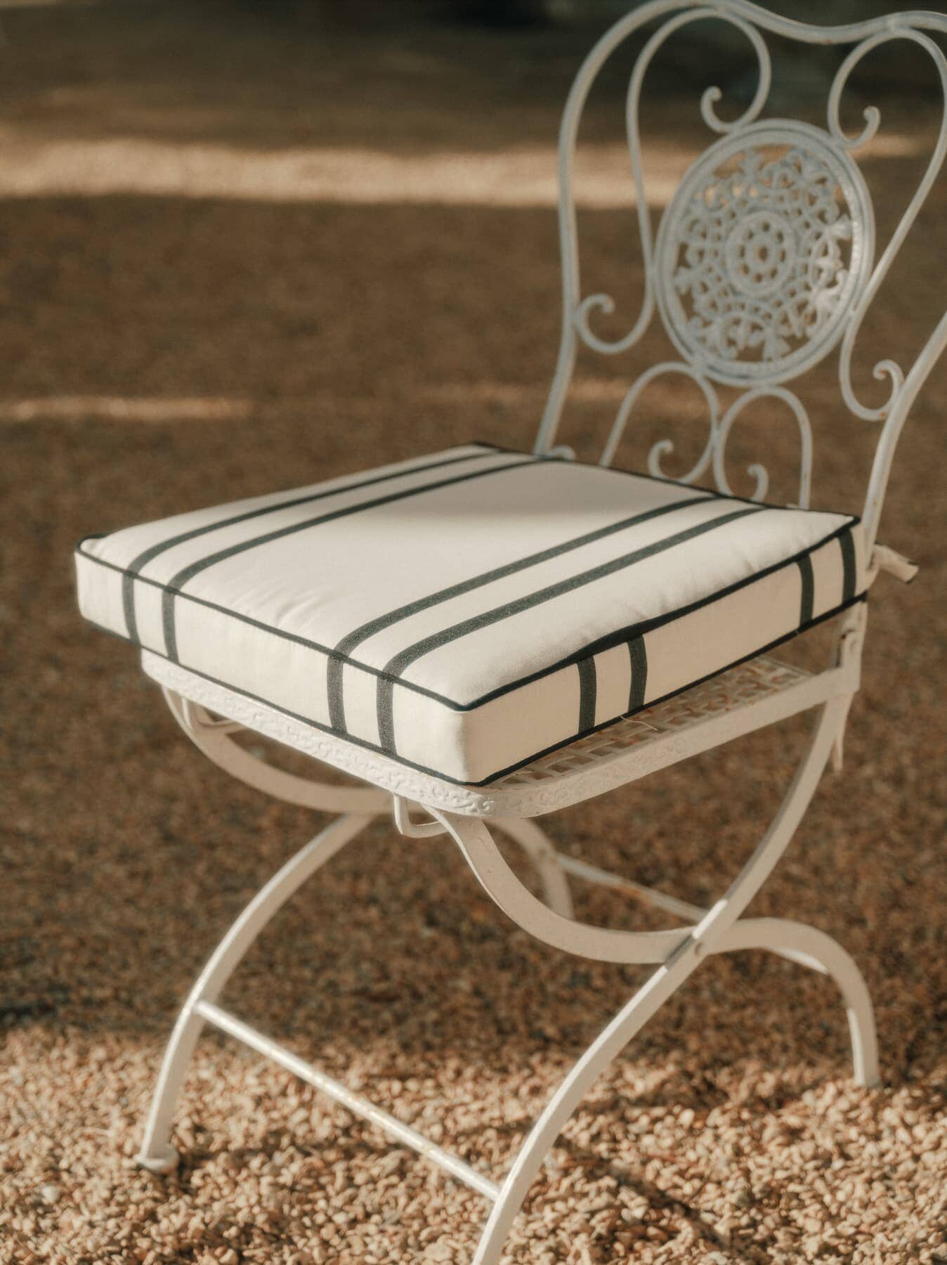 Malibu black stripe seat cushion on a metal chair in a garden