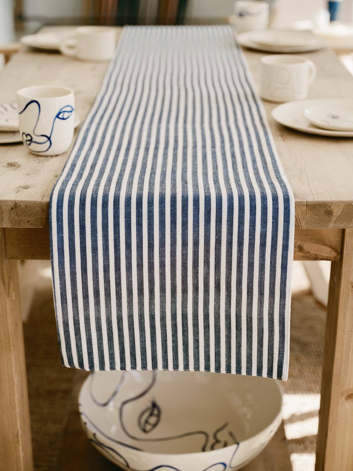 under side of lauren's navy stripe table runner draping off the end of a table