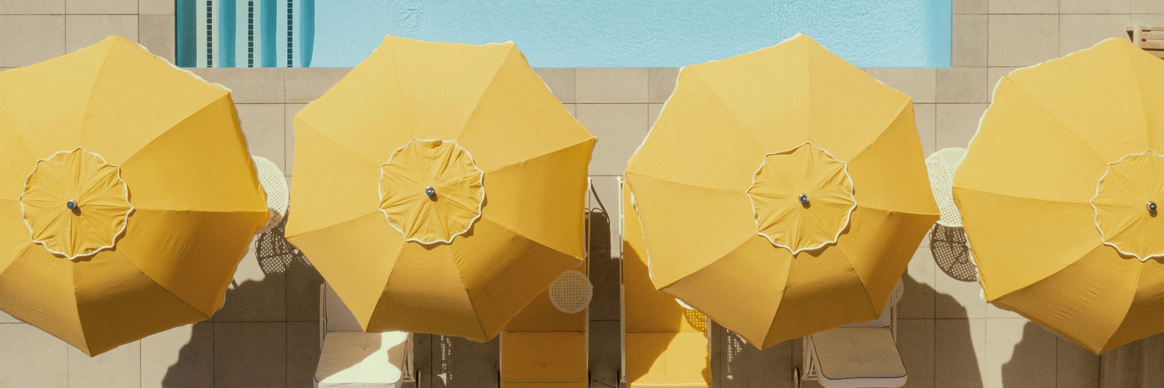 yellow patio umbrella tops poolside