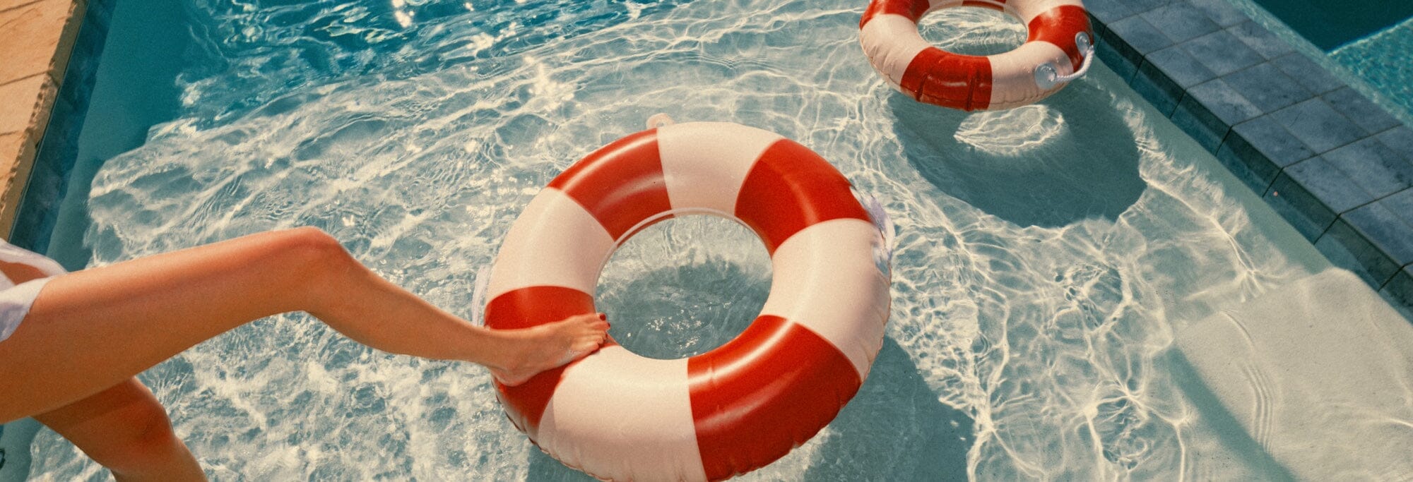 a couple lounging by the pool on the modular pillow stack