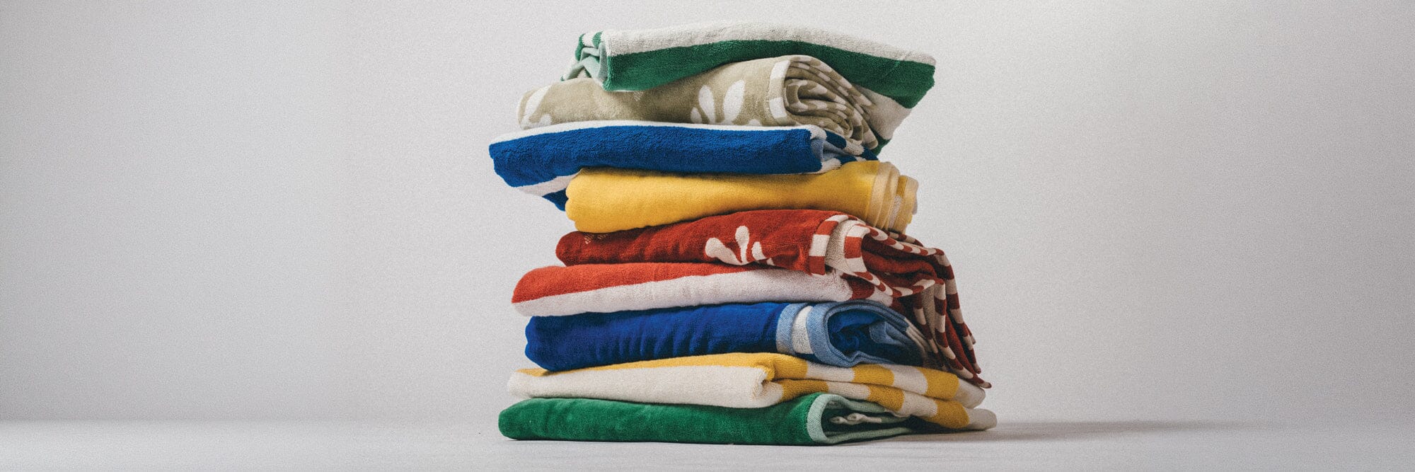 four colorful beach towels on the sand