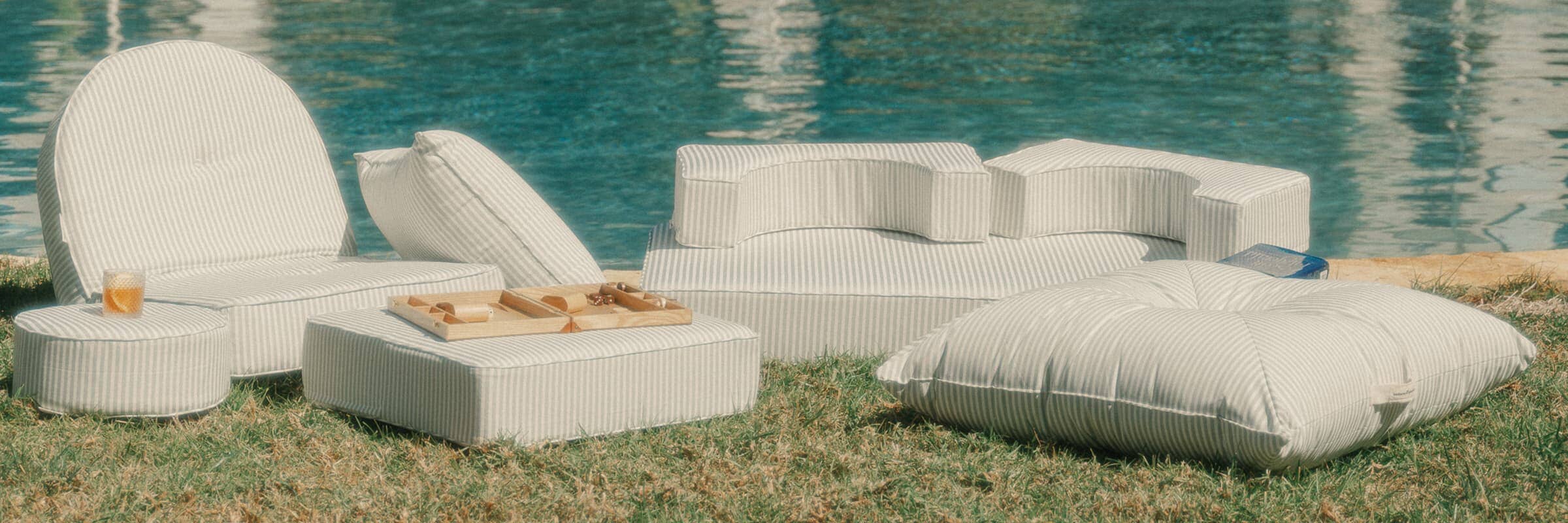 green striped outdoor cushions by a poolside