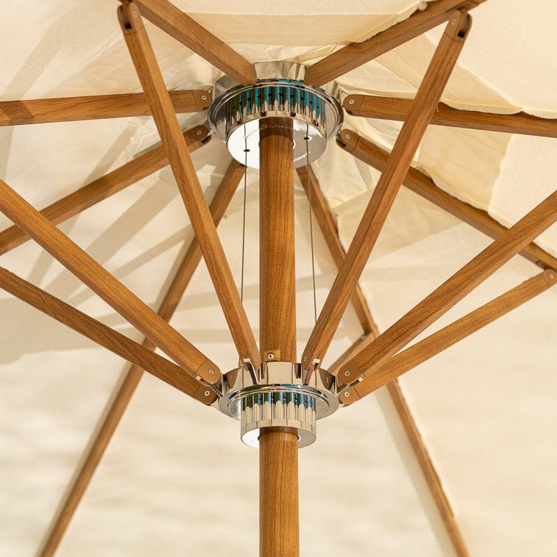 Close-up of a wooden patio umbrella with a beige canopy
