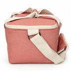 A dusty pink soft-sided cooler bag with cream-colored straps and trim, shown on a clean white background.