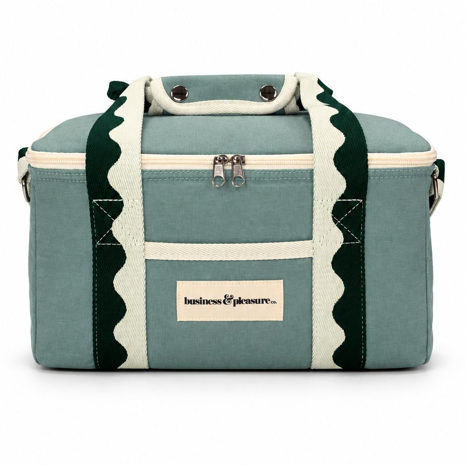 A sage green canvas duffel bag with cream-colored trim and handles featuring a scalloped edge, and a cream label on the front that reads 'london&pigware.