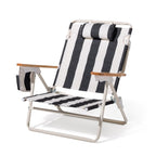 Black and white striped beach chair with wooden armrests on a white background