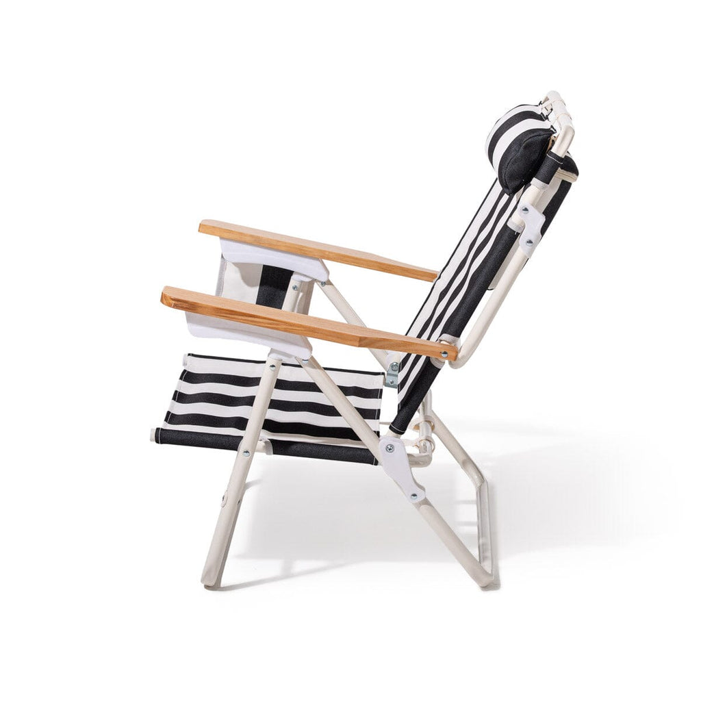 Black and white striped beach chair with wooden armrest on a white background