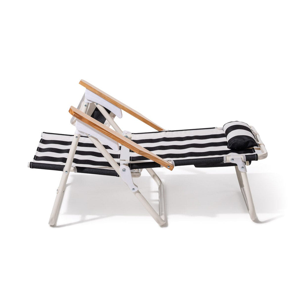 Black and white striped lounge chair with wooden armrests on a white background