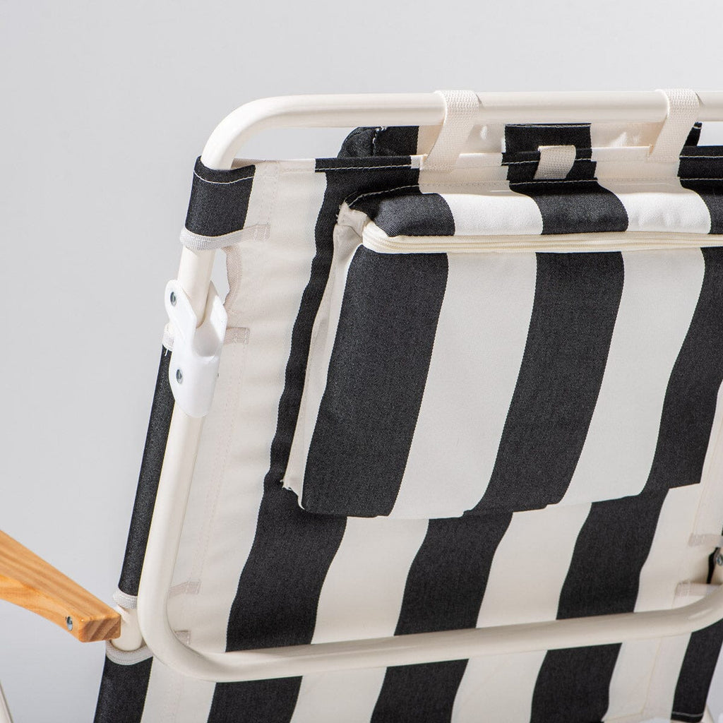 Black and white striped chair with wooden armrests on a light gray background