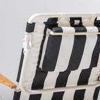 Black and white striped chair with wooden armrests on a light gray background