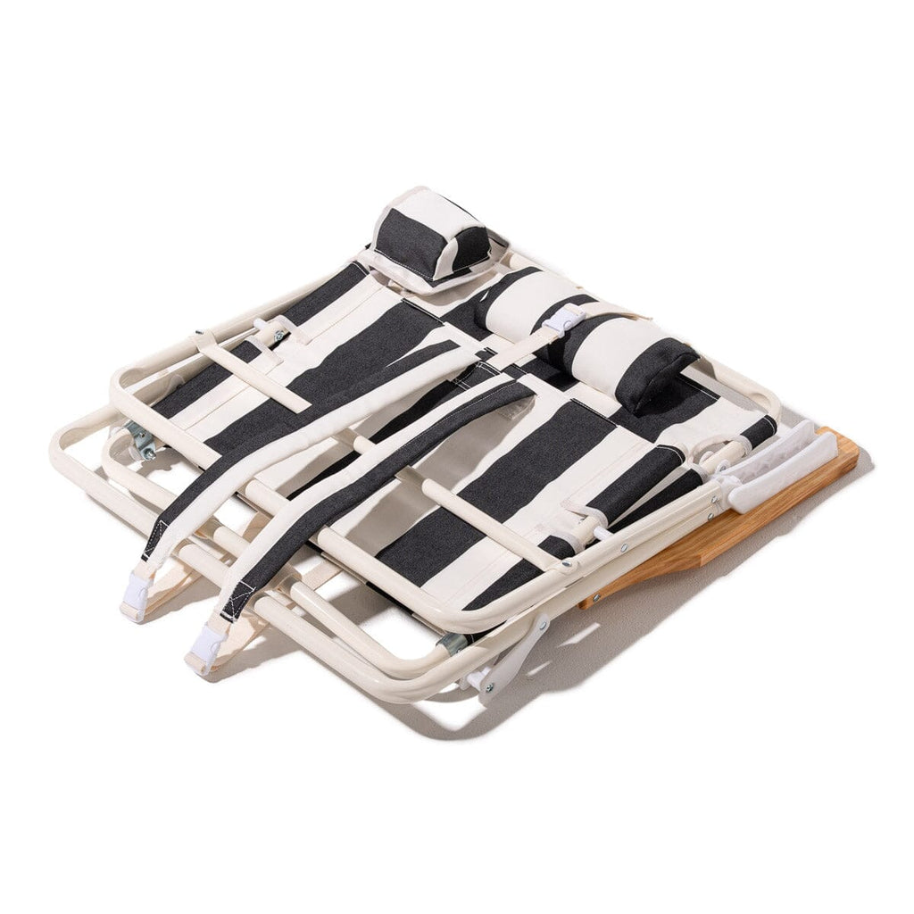 Foldable beach chair with black straps on a white background
