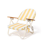 Yellow and white striped folding beach chair on a white background