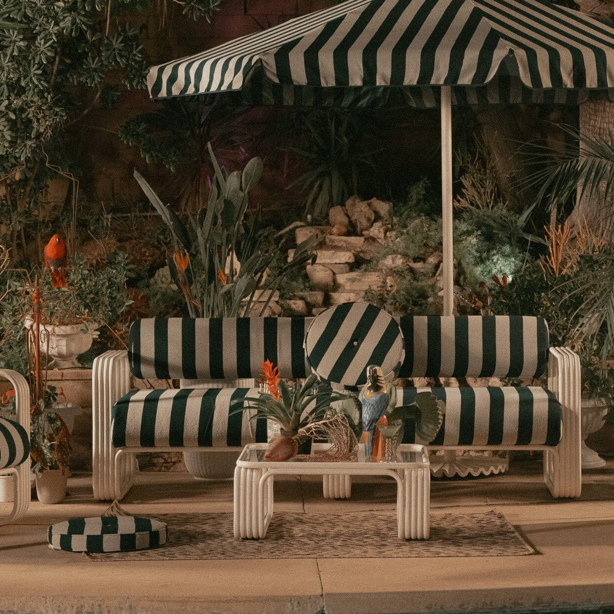 Outdoor patio set with striped furniture and umbrella near a pool