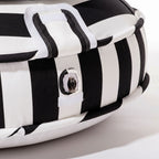 Black and white striped pool float on studio white floor