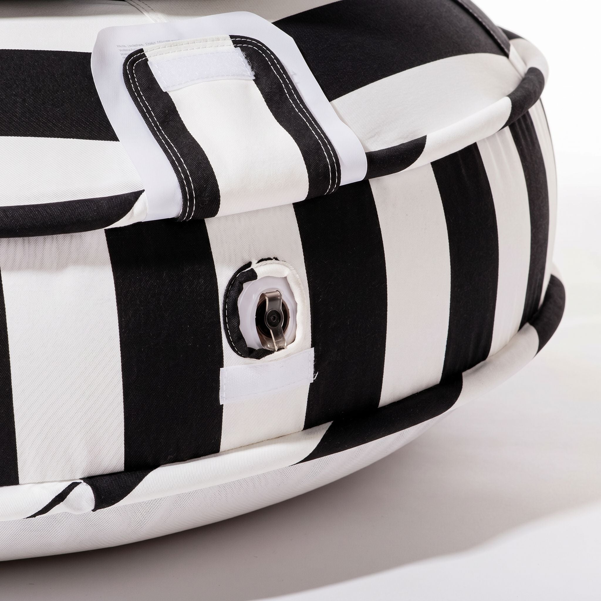 Black and white striped pool float on studio white floor