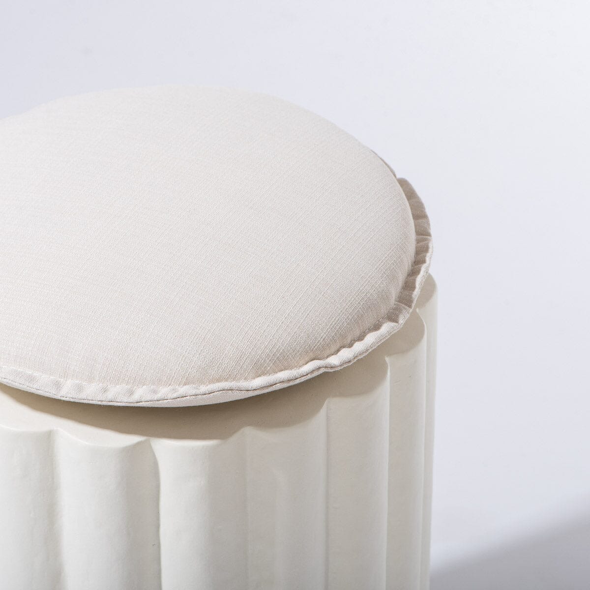 White cushioned stool on a light gray background
