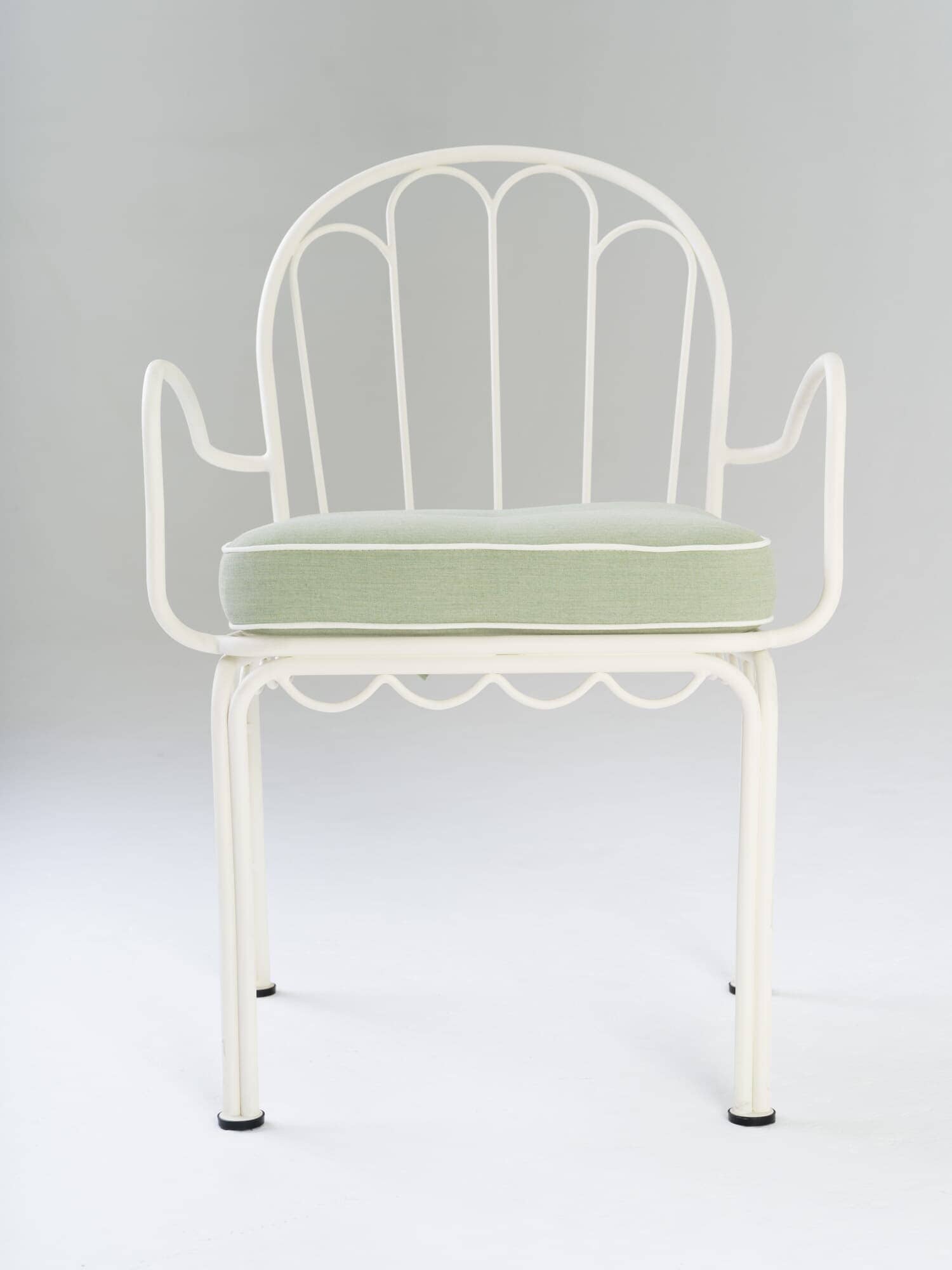 front view of green chair cushion on white metal chair in studio