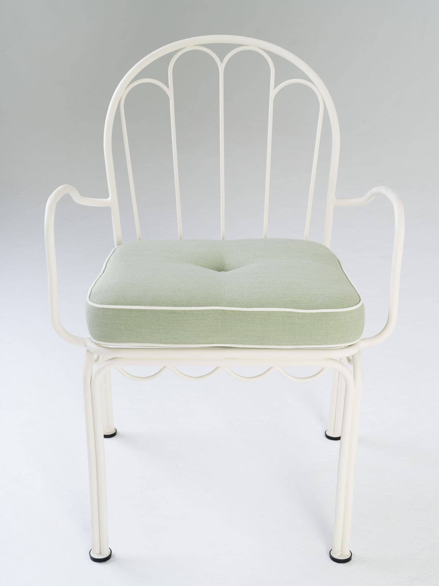 top view of green chair cushion and white metal chair in studio