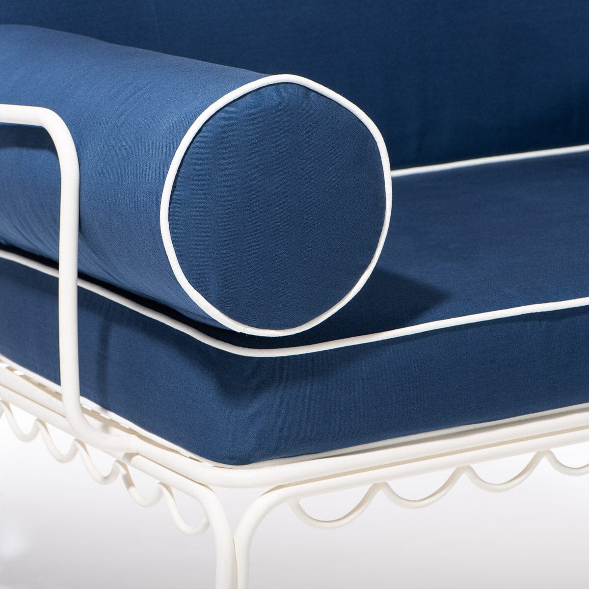 Blue cushion with white piping on a white metal frame