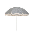 Business & Pleasure Co. Patio Umbrella in Laurens Navy Stripe, featuring a dome-shaped canopy with fine navy and white stripes, scalloped edges, cream fringe trim and a white center pole.