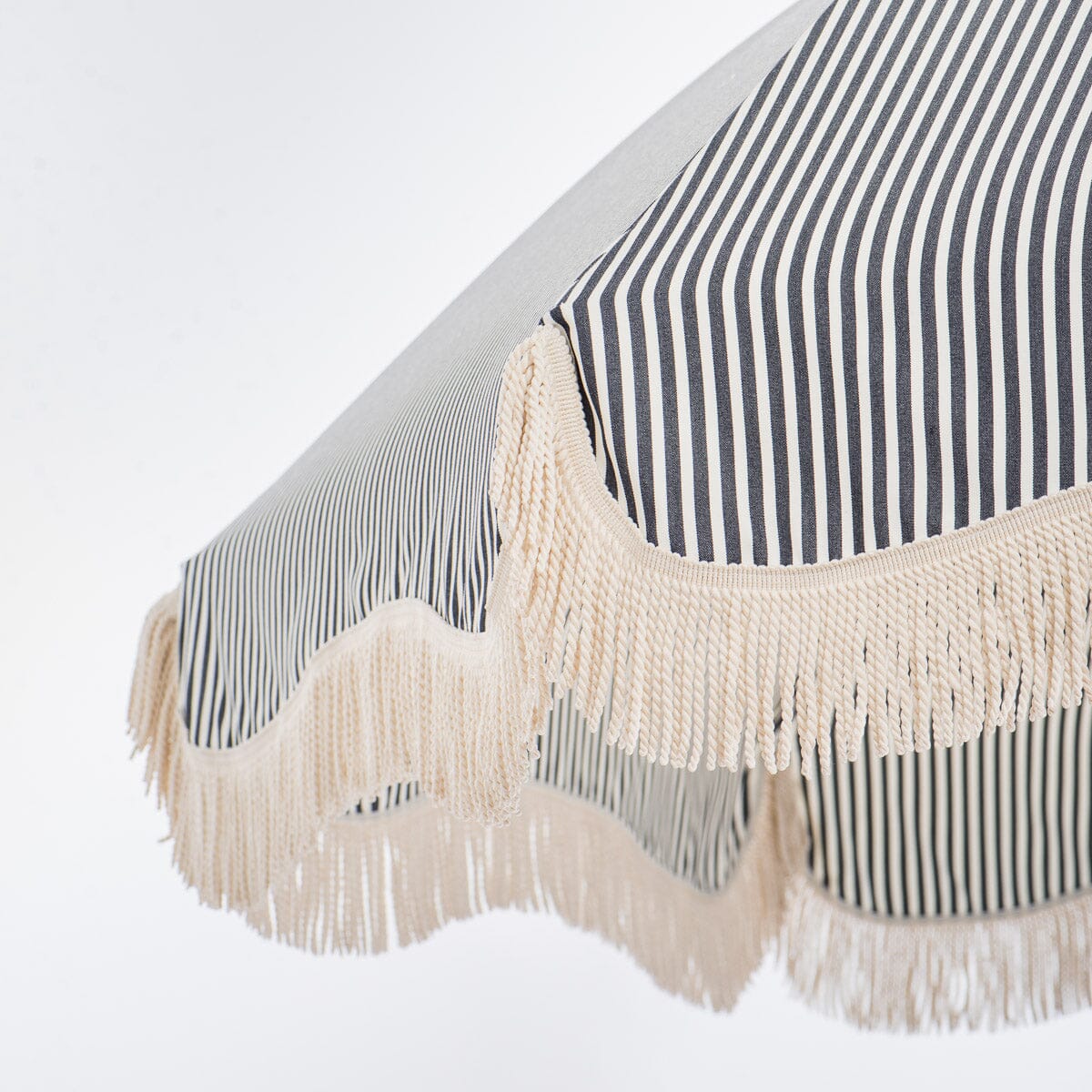 close up of fringe on navy stripe patio umbrella