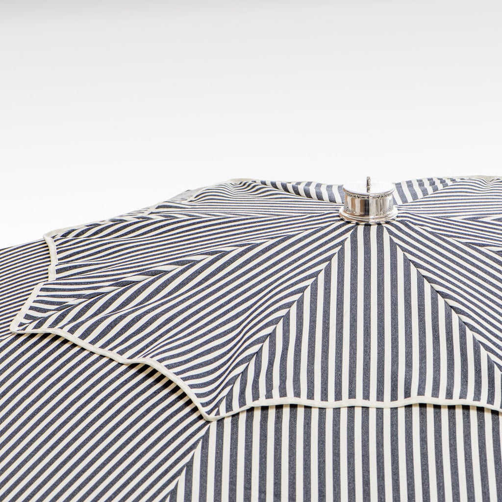 close up of chrome top cap on navy stripe patio umbrella