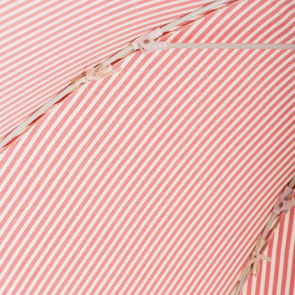 close up of canopy ties on pink stripe patio umbrella
