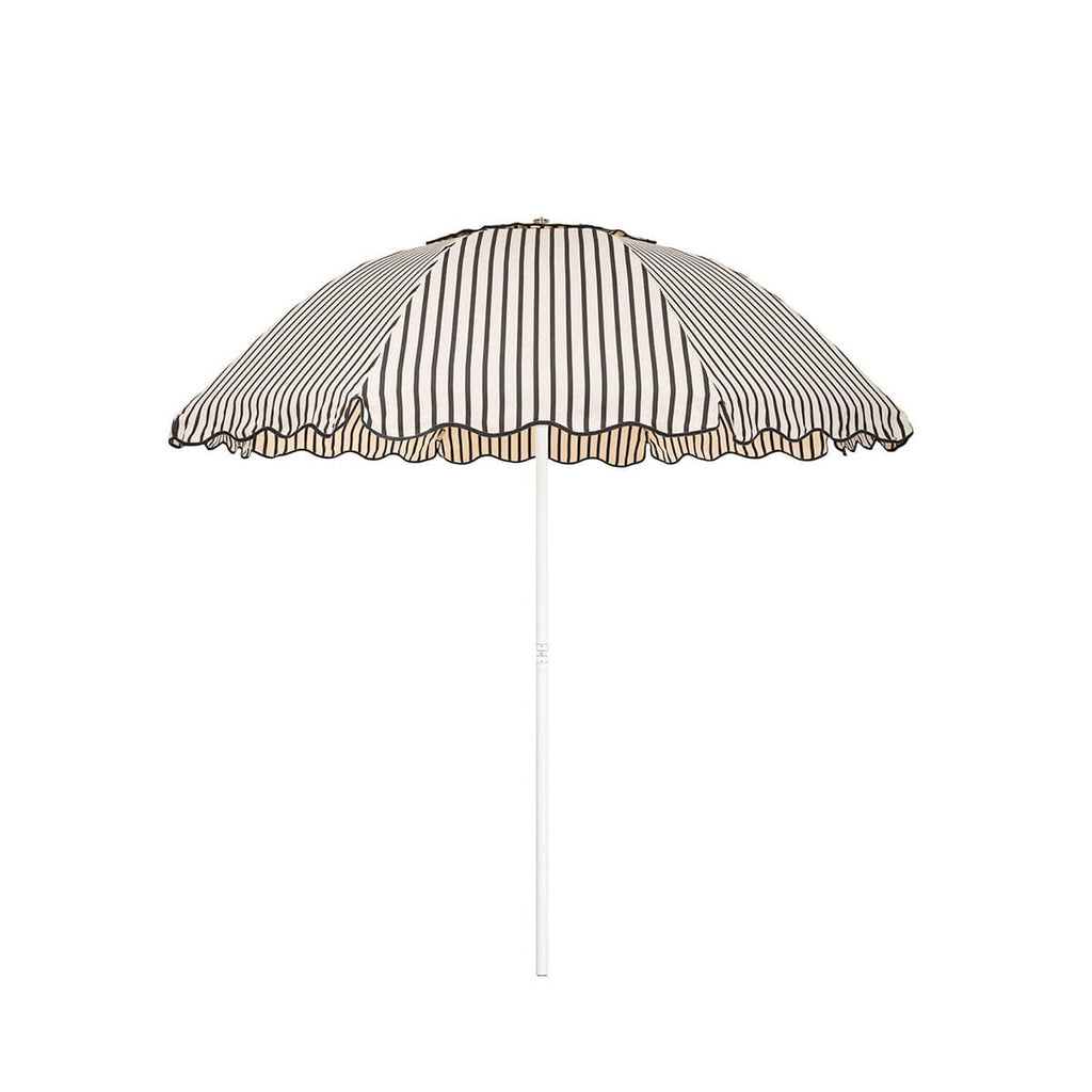 Business & Pleasure Co. Patio Umbrella in Monaco Black Stripe, featuring a dome-shaped cream canopy with fine black stripes, scalloped edges, black piping and a white center pole.