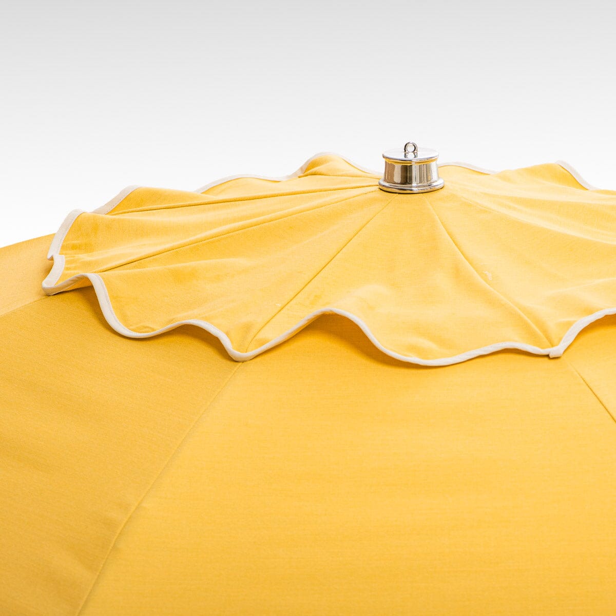 chrome top cap detail on yellow patio umbrella