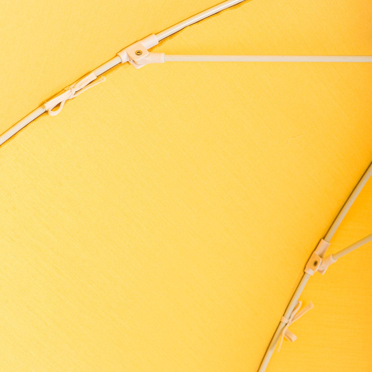 close up detail of canopy ties on yellow patio umbrella