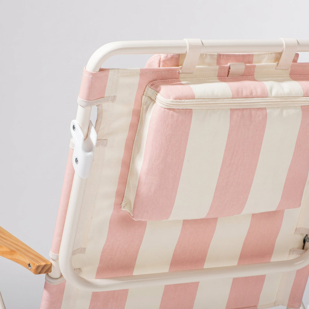 Pink and white striped beach chair back detail showing cooler pouch with a white background
