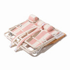 Pink and white beach chair folded down to show backpack straps on a white background
