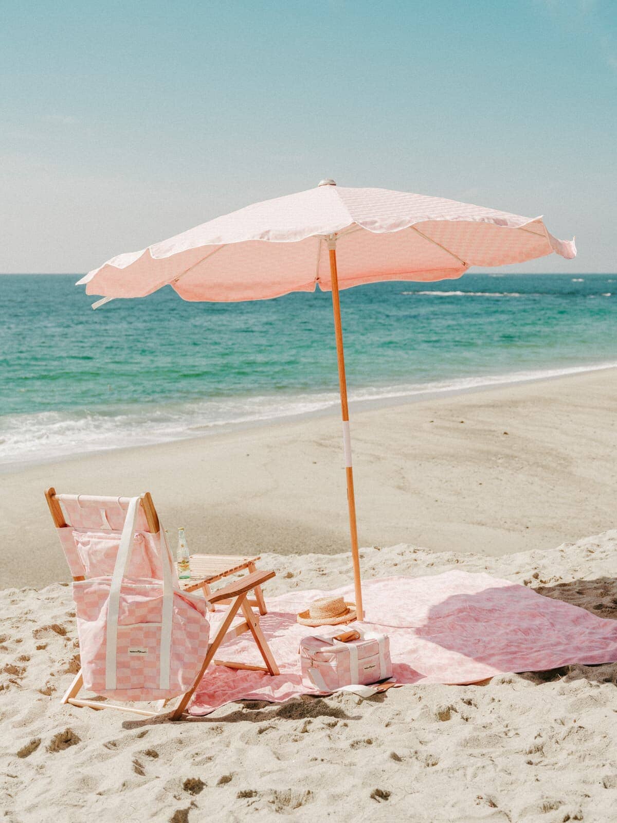 dusty pink amalfi on the beach with a blanket, tommy chair and accessories