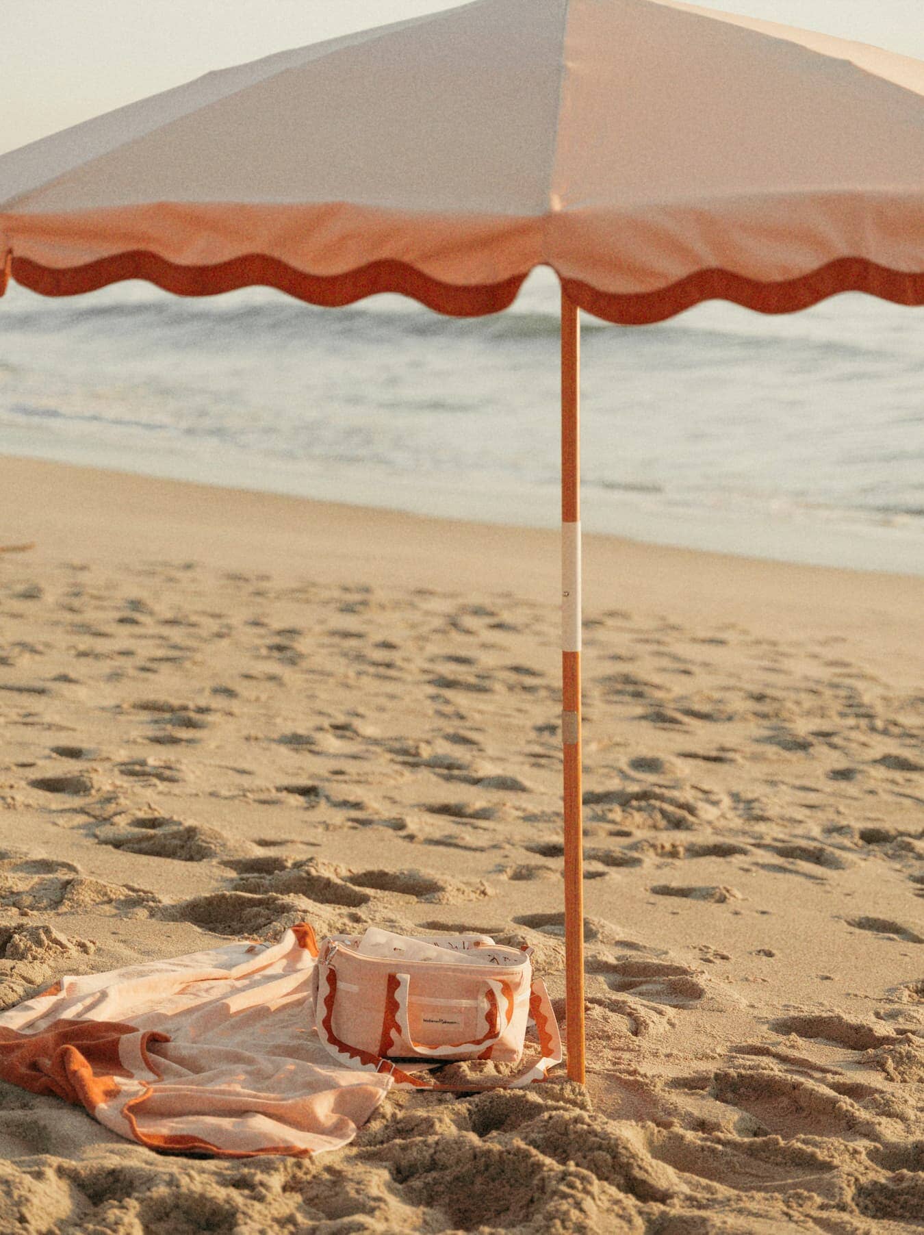 Riviera pink beach set up with umbrella, towel and cooler