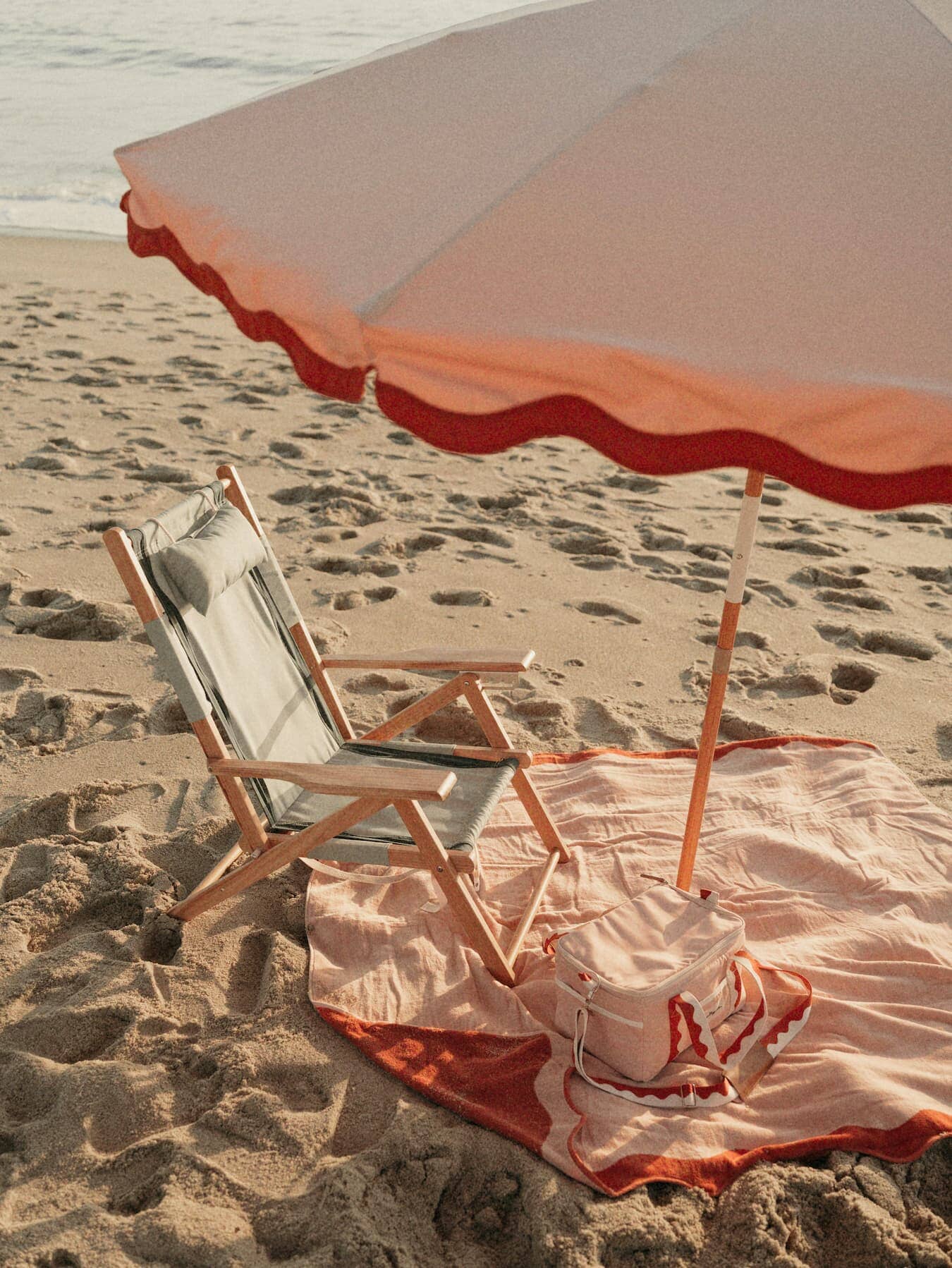 Riviera pink umbrella, blanket, cooler on the beach