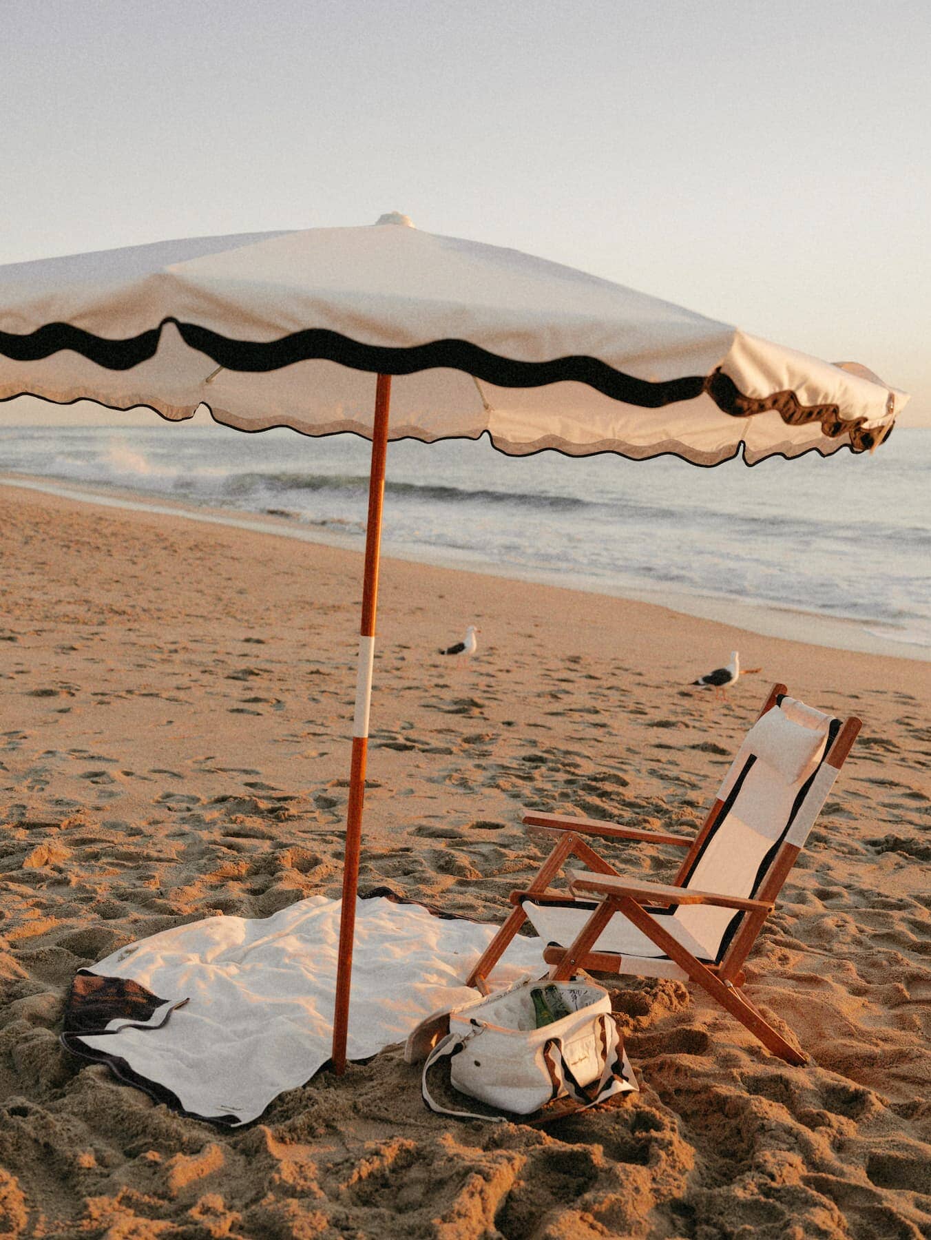 Riviera white beach set up with umbrella, chair, towel and cooler