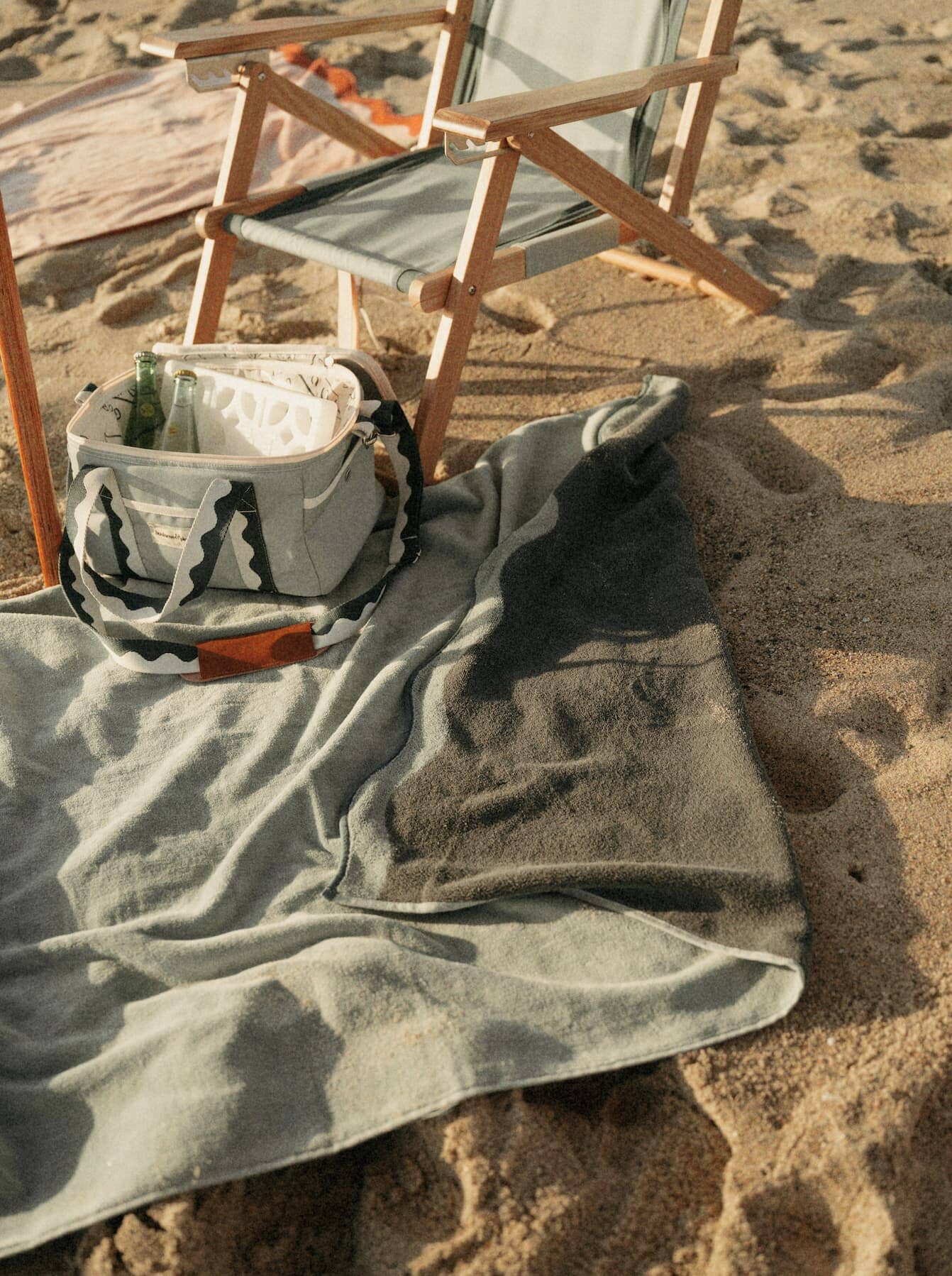 riviera green towel and cooler bag on the beach