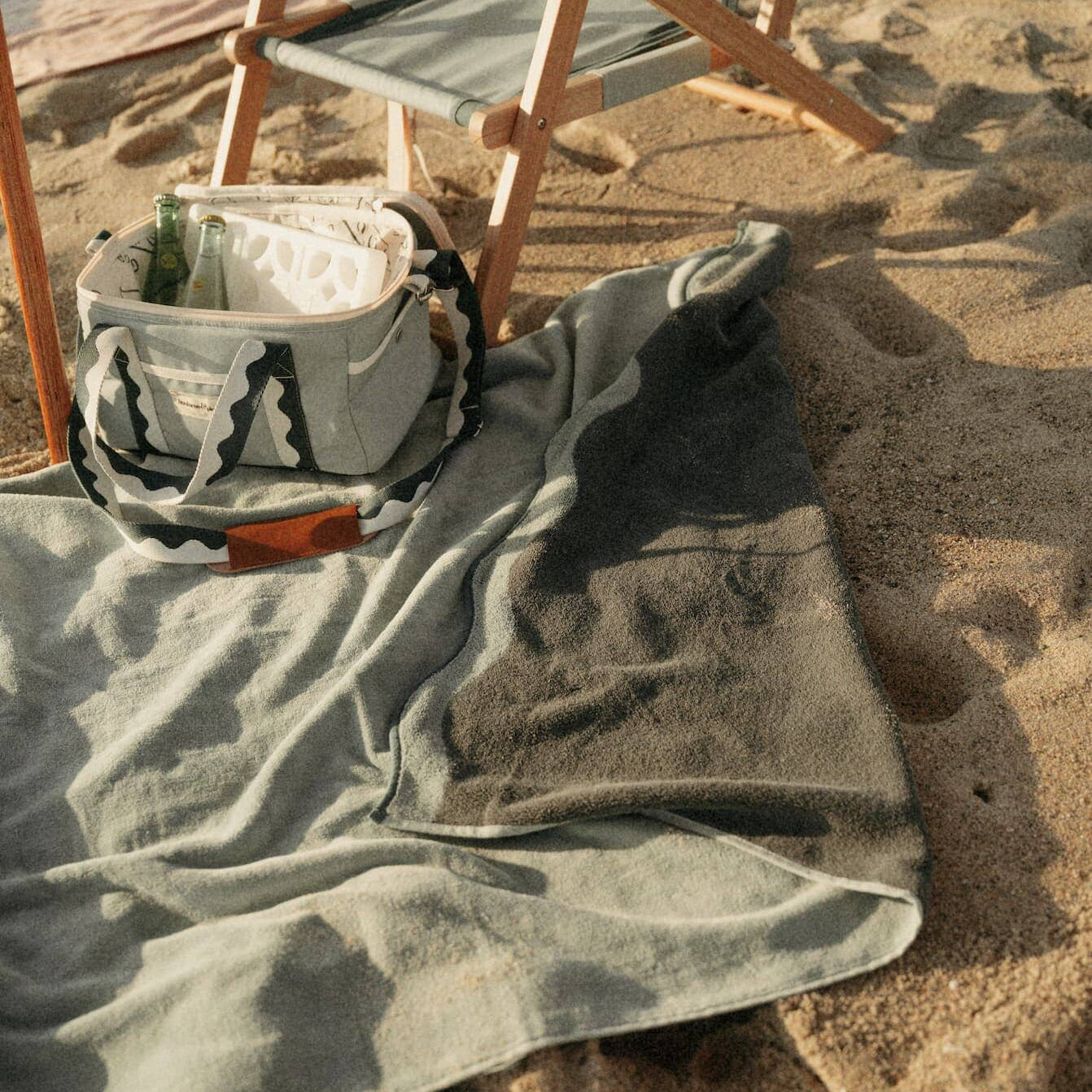 riviera green towel and cooler bag on the beach