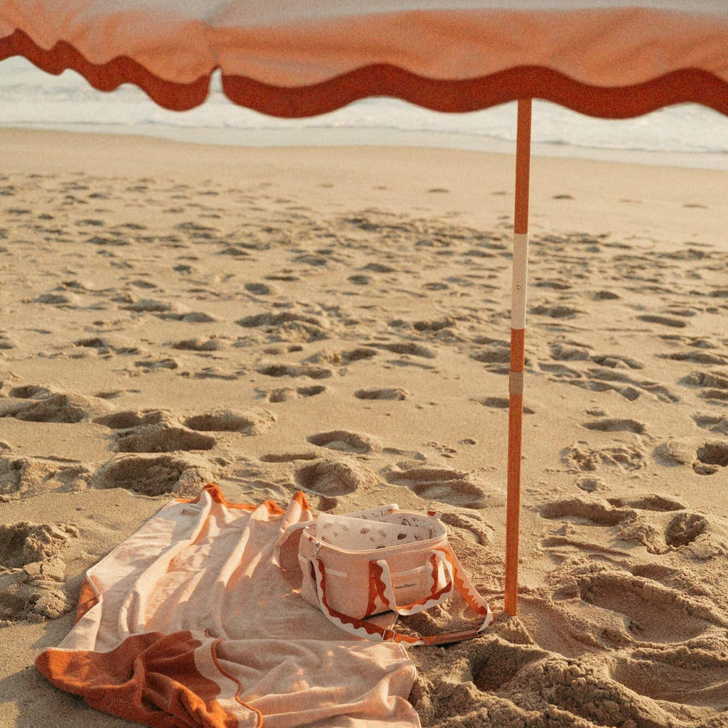 Riviera pink beach set up with umbrella, towel and cooler