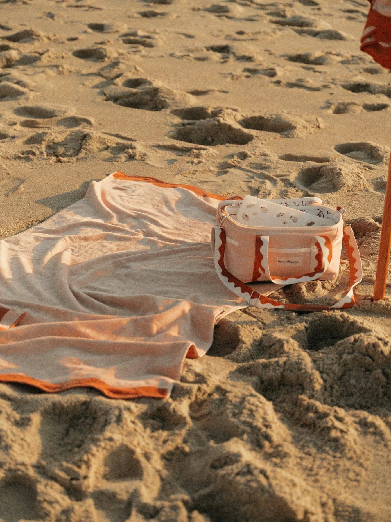 Riviera pink towel and cooler on the beach