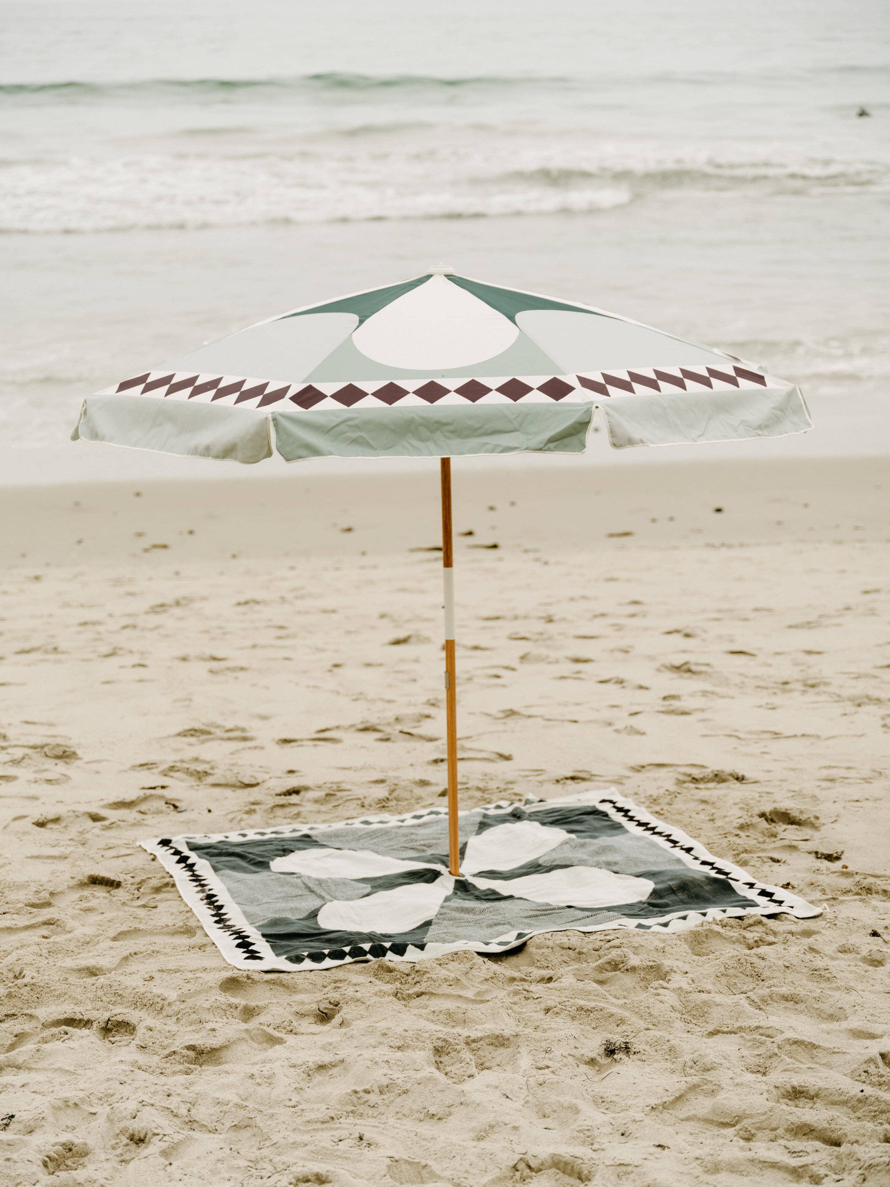 beach set up with diamond green blanket & umbrella