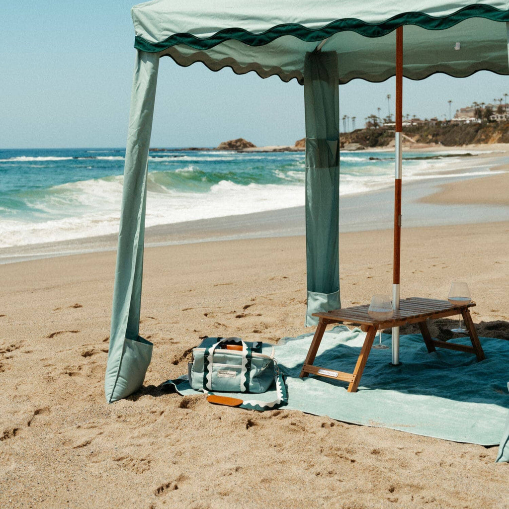 riviera green beach set up with cabana, blanket, cooler and table