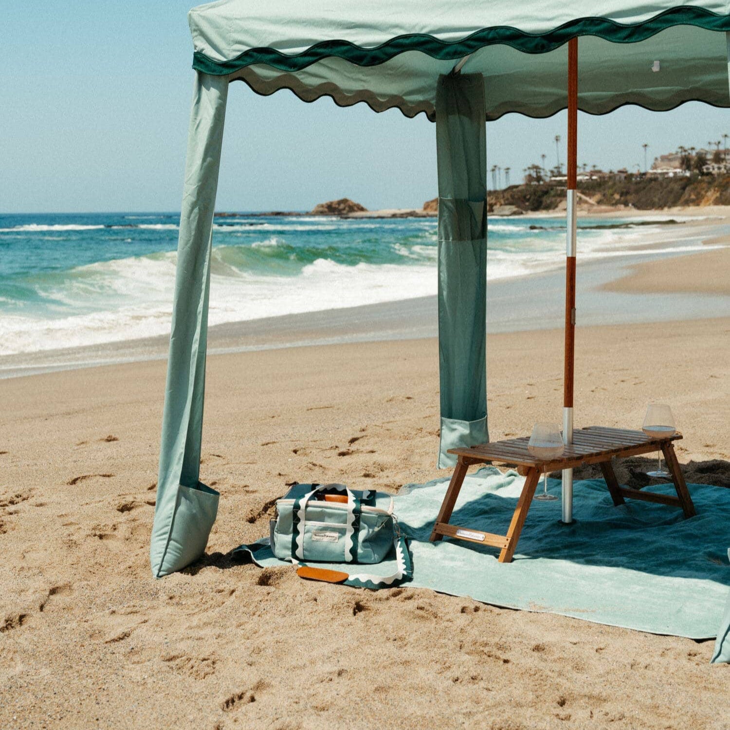 riviera green beach set up with cabana, blanket, cooler and table