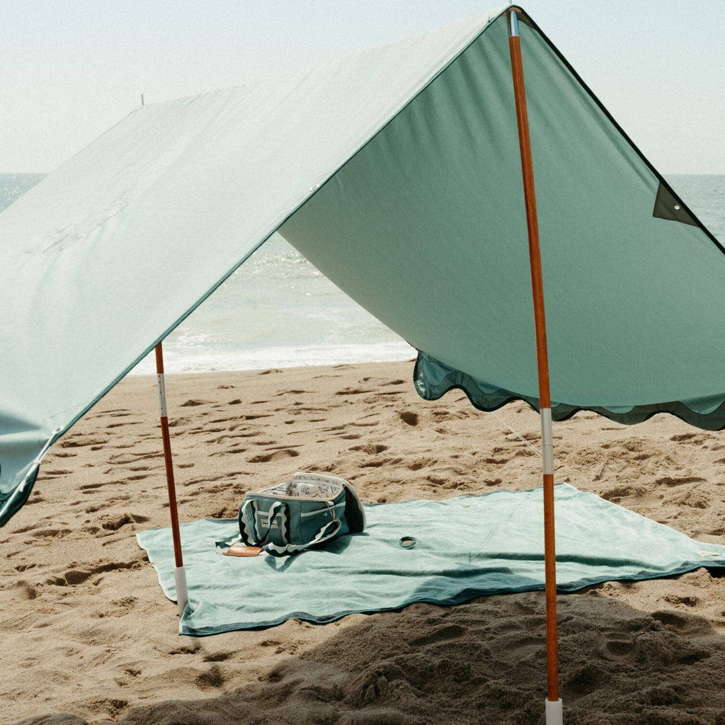 riviera green tent with blanket and cooler on the beach