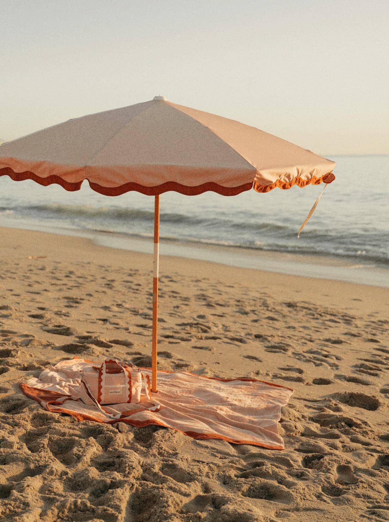 riviera pink blanket, umbrella and cooler on the beach