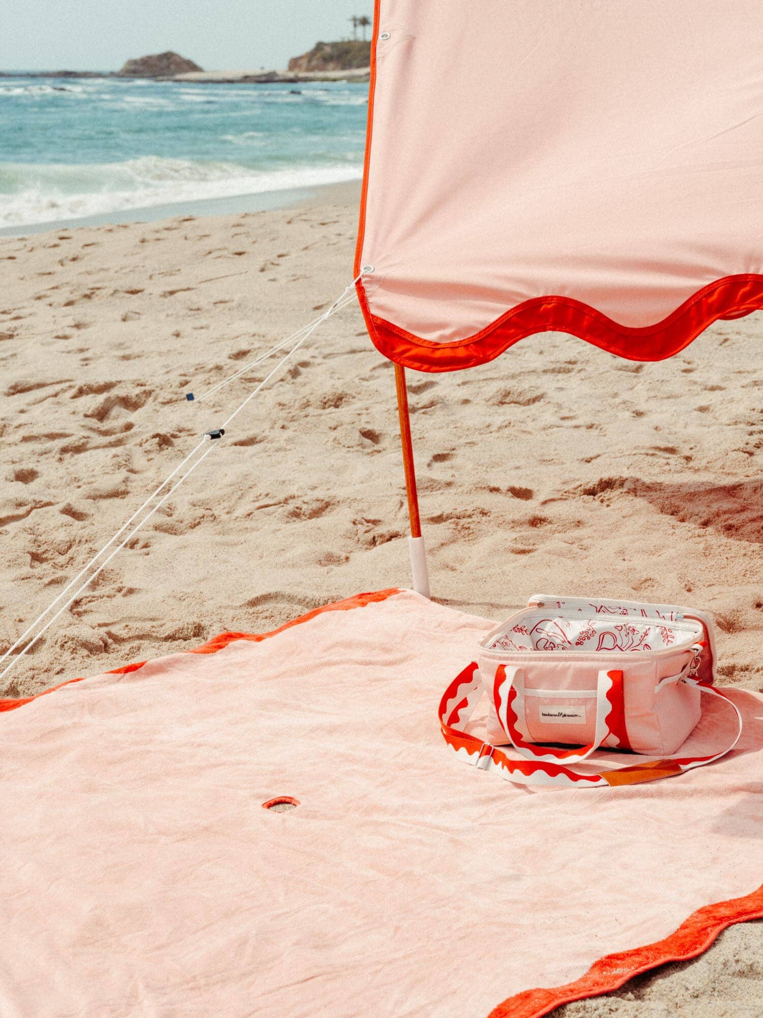 riviera pink tent, blanket and cooler on the beach